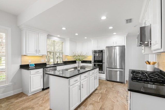 kitchen featuring visible vents, white cabinets, appliances with stainless steel finishes, and a sink