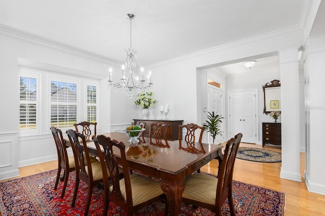 dining area featuring an inviting chandelier, baseboards, light wood-style floors, and ornamental molding