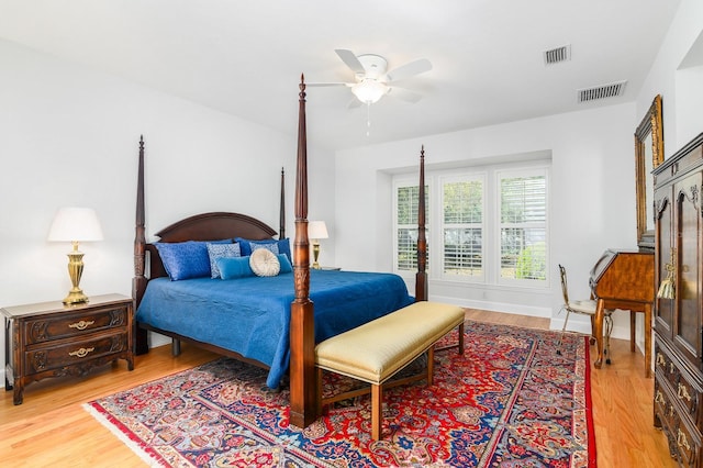 bedroom with light wood finished floors, visible vents, and ceiling fan