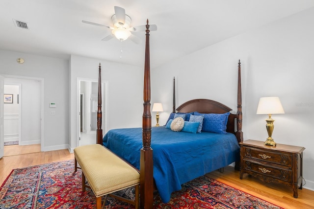 bedroom with light wood-style flooring, a ceiling fan, visible vents, and baseboards