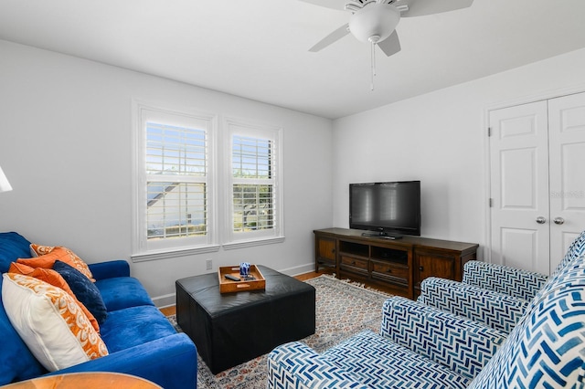 living room with wood finished floors, baseboards, and ceiling fan