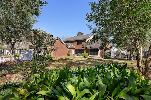 view of front of home featuring fence and brick siding