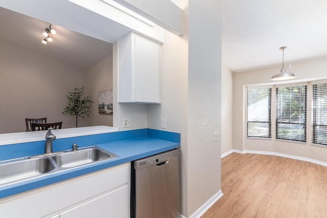 kitchen featuring baseboards, dishwasher, light wood-style flooring, white cabinetry, and a sink