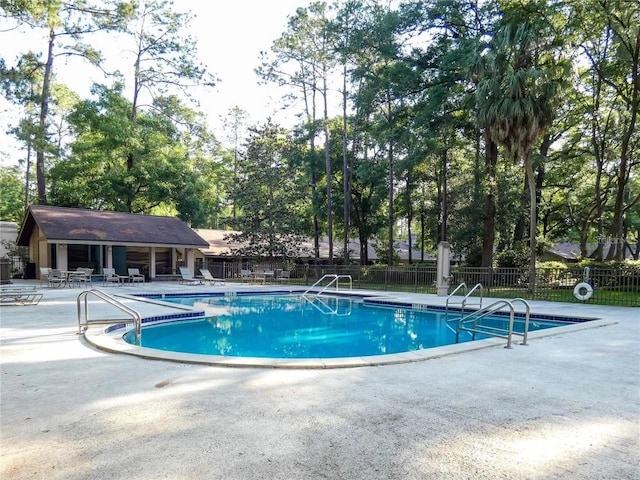 community pool featuring a patio area and fence