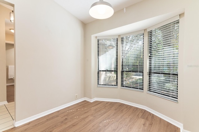 unfurnished room with baseboards and wood finished floors