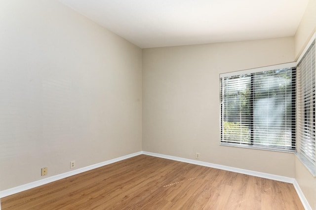 unfurnished room with light wood-type flooring and baseboards