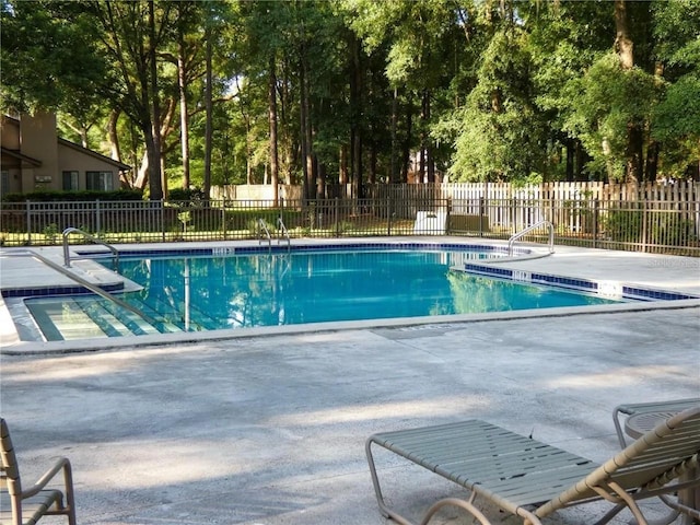 community pool with fence and a patio