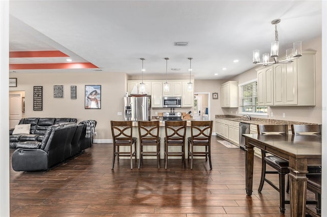 dining room featuring a notable chandelier, recessed lighting, dark wood-type flooring, visible vents, and baseboards