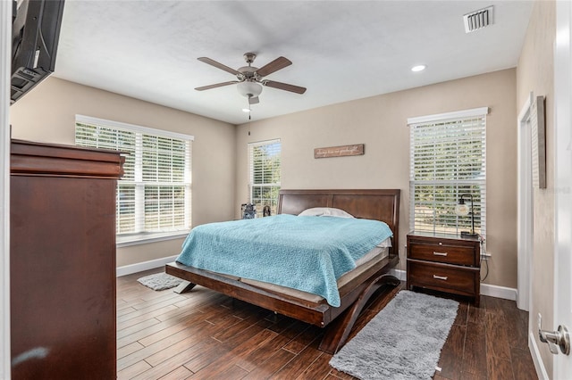 bedroom with visible vents, baseboards, ceiling fan, and dark wood-type flooring