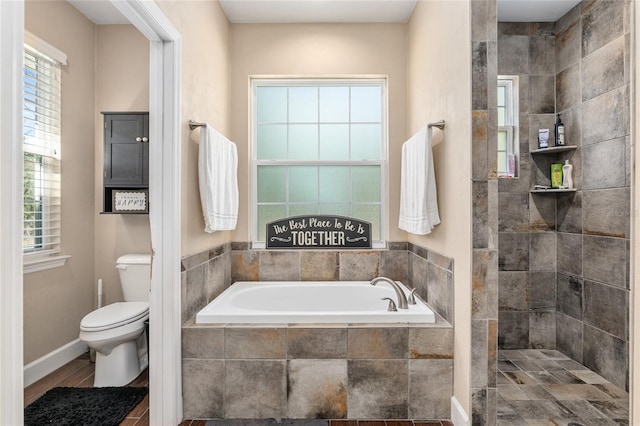 bathroom featuring toilet, tiled shower, a bath, and a healthy amount of sunlight