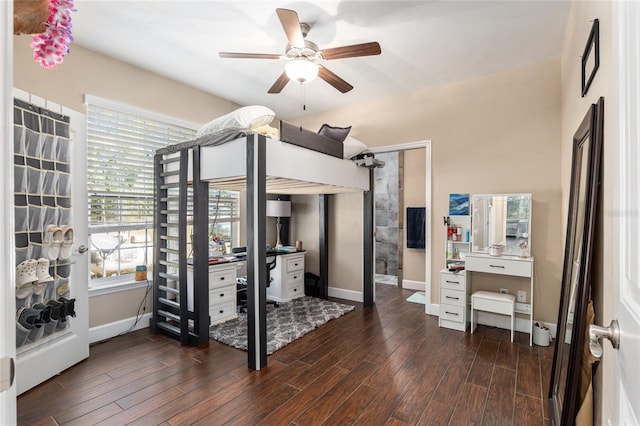 bedroom featuring dark wood-style floors, ceiling fan, baseboards, and multiple closets