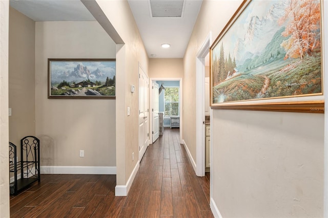 hallway featuring dark wood-style flooring, visible vents, and baseboards