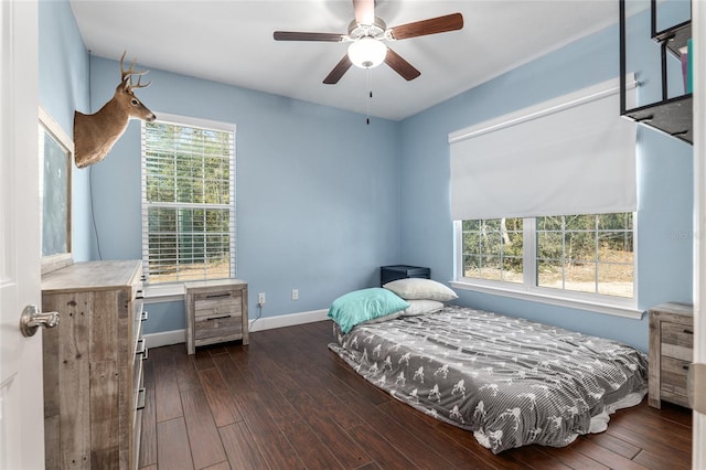 bedroom featuring ceiling fan, dark wood-style flooring, and baseboards