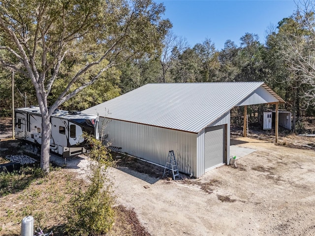 view of property exterior featuring metal roof and an outdoor structure