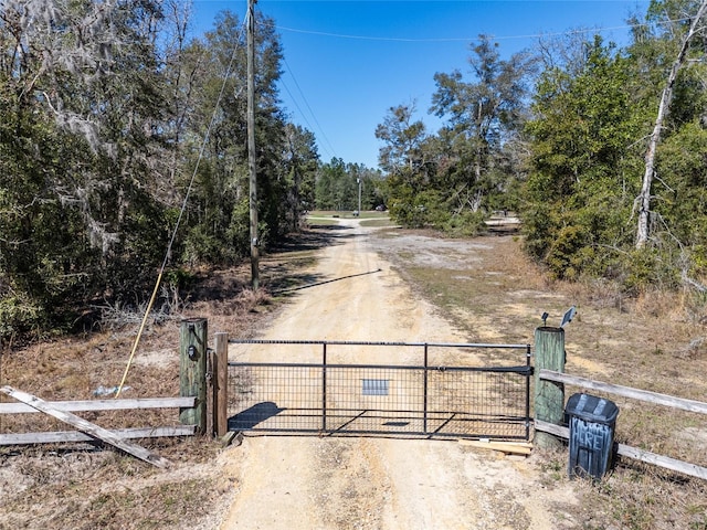 view of road featuring driveway, a gate, and a gated entry