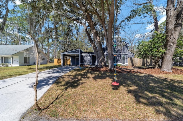 view of front of home with driveway, fence, a carport, and a front yard