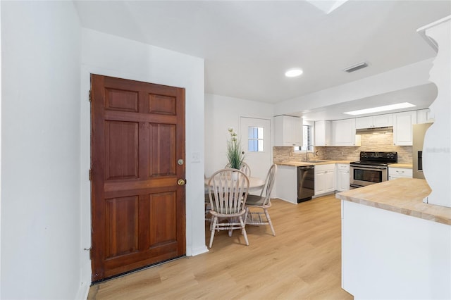 kitchen featuring dishwasher, stainless steel electric stove, light countertops, under cabinet range hood, and a sink