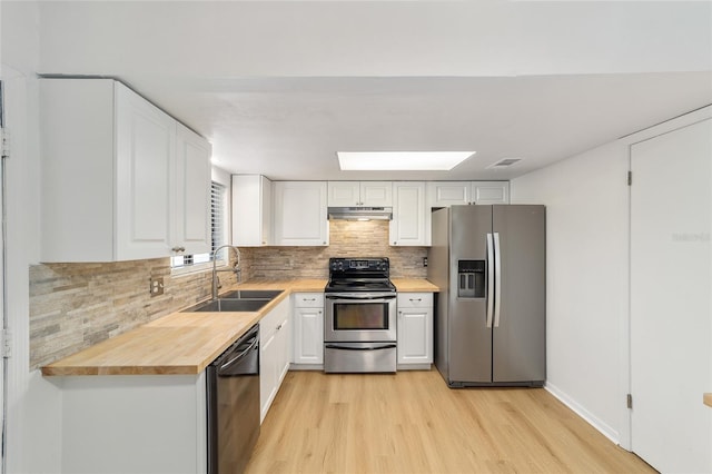 kitchen featuring stainless steel appliances, white cabinetry, a sink, and under cabinet range hood