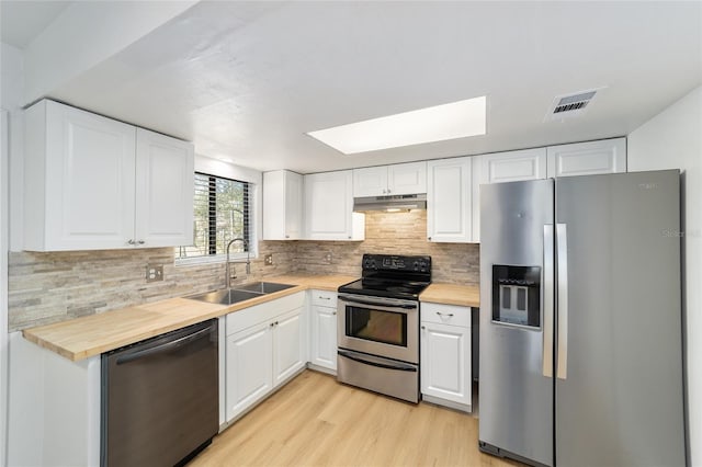 kitchen with visible vents, wood counters, appliances with stainless steel finishes, under cabinet range hood, and a sink