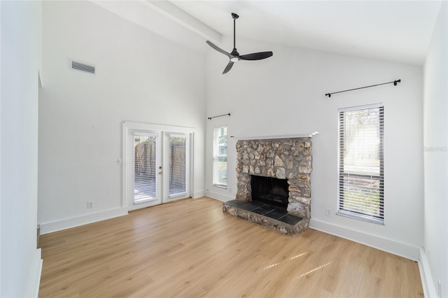 unfurnished living room featuring visible vents, a fireplace, baseboards, and wood finished floors