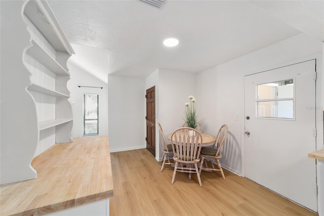 dining space with light wood-style flooring and visible vents