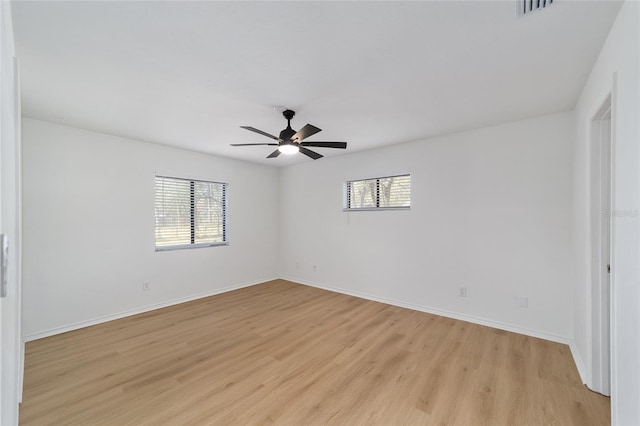 unfurnished room featuring visible vents, light wood-style flooring, and baseboards