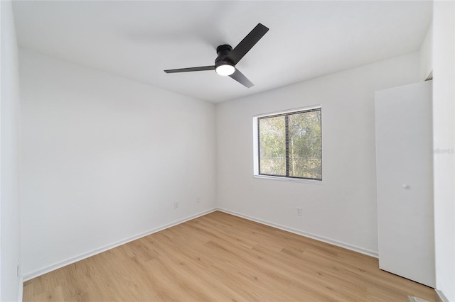 unfurnished room featuring ceiling fan, light wood finished floors, and baseboards