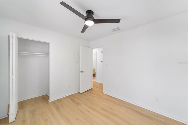 unfurnished bedroom with a ceiling fan, visible vents, baseboards, a closet, and light wood finished floors