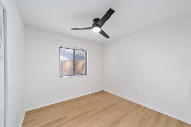 spare room with light wood-style flooring, baseboards, and a ceiling fan