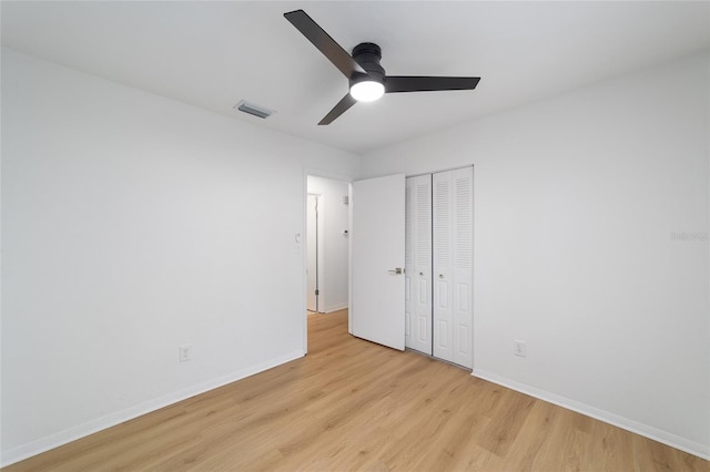 unfurnished bedroom featuring a closet, visible vents, ceiling fan, light wood-type flooring, and baseboards