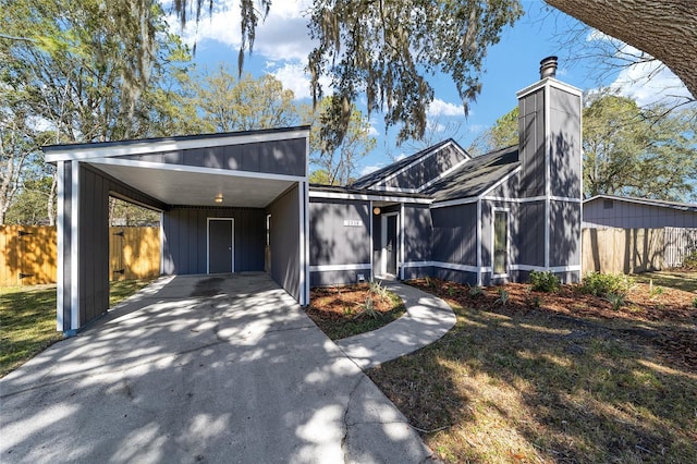 view of front of house featuring a front yard, a sunroom, fence, a carport, and driveway