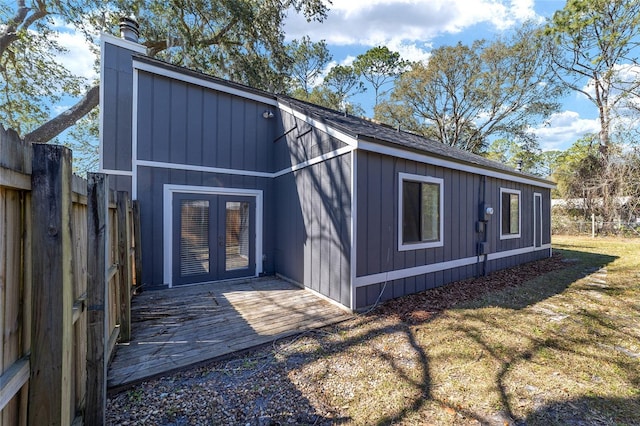 view of outdoor structure with french doors and fence