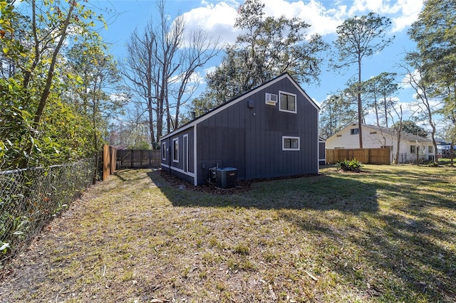 view of outdoor structure with a fenced backyard and central AC unit