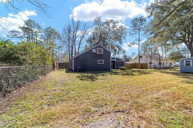 view of yard with central air condition unit, a fenced backyard, and an outdoor structure