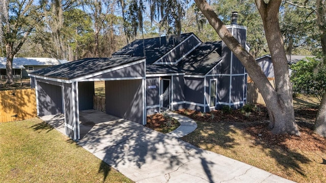 exterior space with driveway, a front yard, fence, and a sunroom