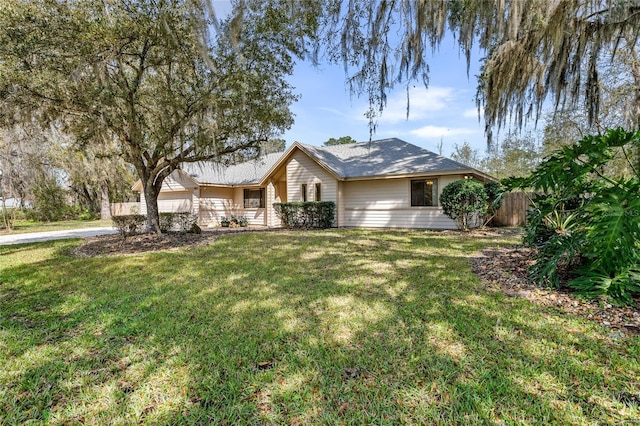 ranch-style home with a front yard and fence