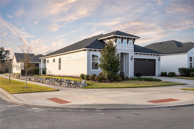 view of front of home featuring concrete driveway, a front lawn, and an attached garage