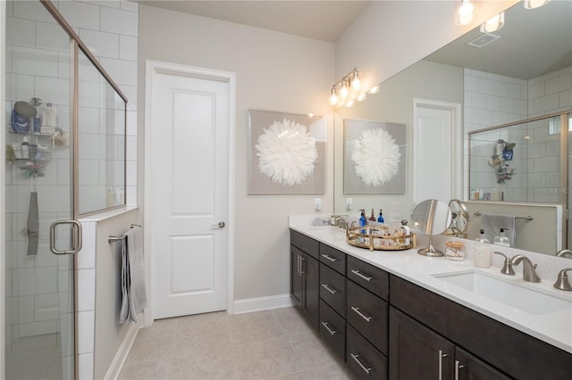 full bathroom with double vanity, a shower stall, a sink, and tile patterned floors