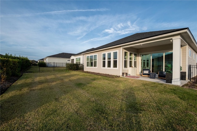 back of house featuring a fenced backyard, a lawn, and a patio