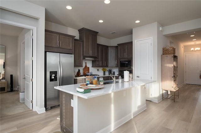 kitchen with stainless steel appliances, light countertops, dark brown cabinetry, and recessed lighting