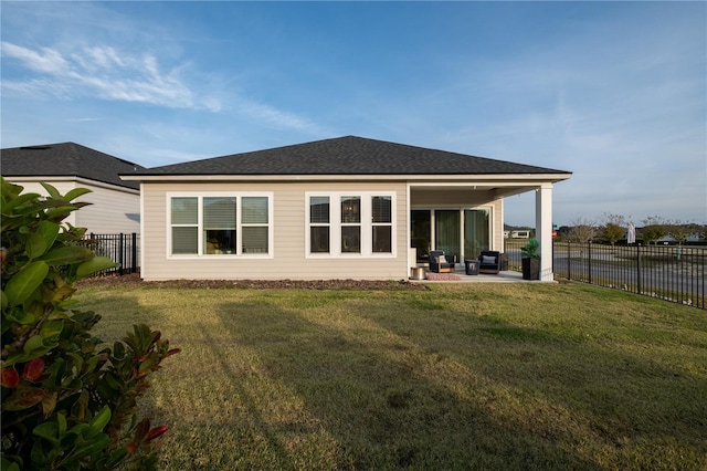 rear view of property with a patio area, a yard, and a fenced backyard