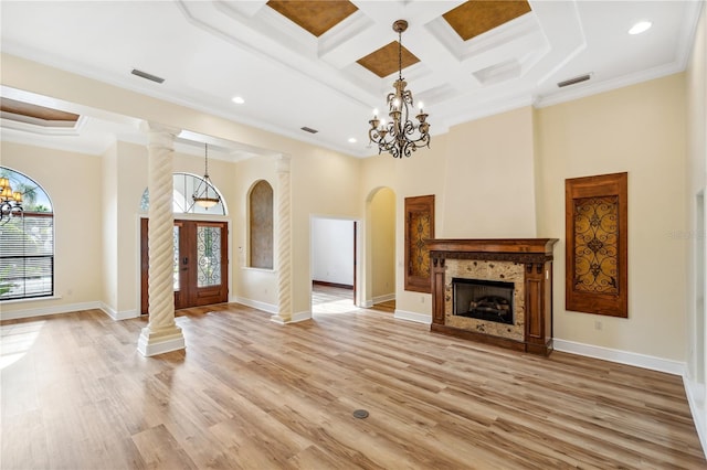 unfurnished living room featuring light wood-style floors, visible vents, arched walkways, and a chandelier