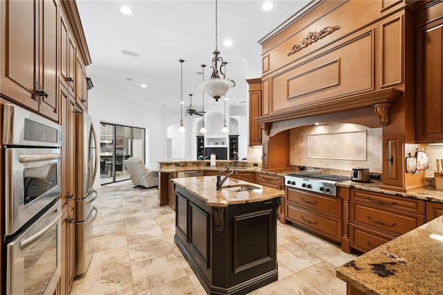 kitchen with a peninsula, a sink, stainless steel appliances, pendant lighting, and tasteful backsplash