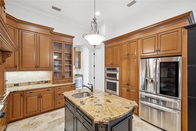 kitchen with brown cabinets, visible vents, appliances with stainless steel finishes, and a sink