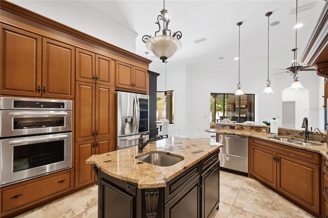 kitchen with pendant lighting, brown cabinets, appliances with stainless steel finishes, and a sink