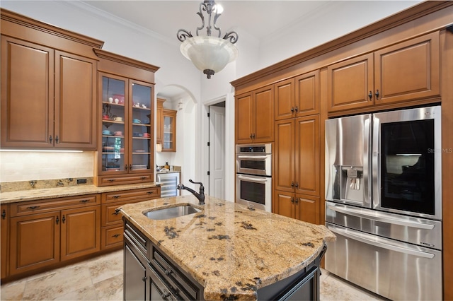 kitchen with a sink, ornamental molding, light stone countertops, and stainless steel appliances