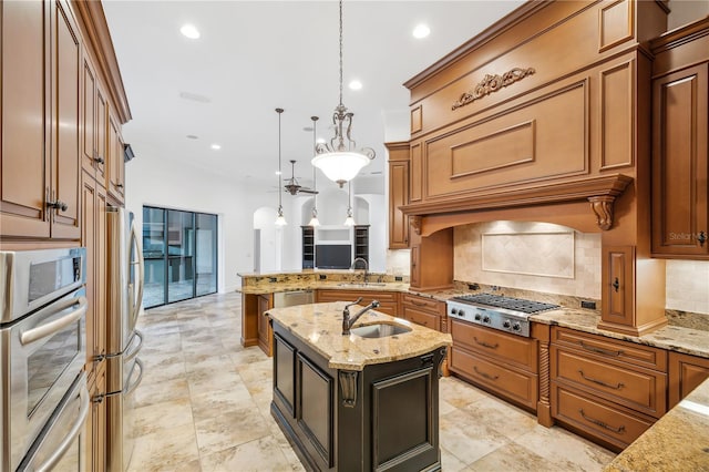 kitchen featuring a peninsula, a sink, hanging light fixtures, decorative backsplash, and stainless steel appliances