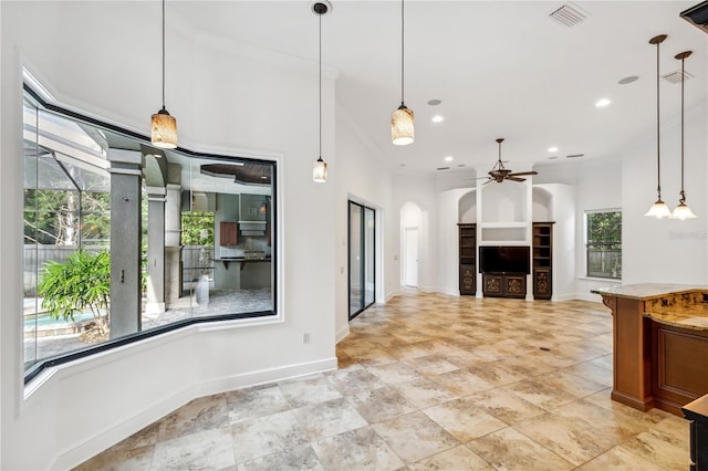 kitchen featuring visible vents, ceiling fan, light stone countertops, brown cabinets, and arched walkways