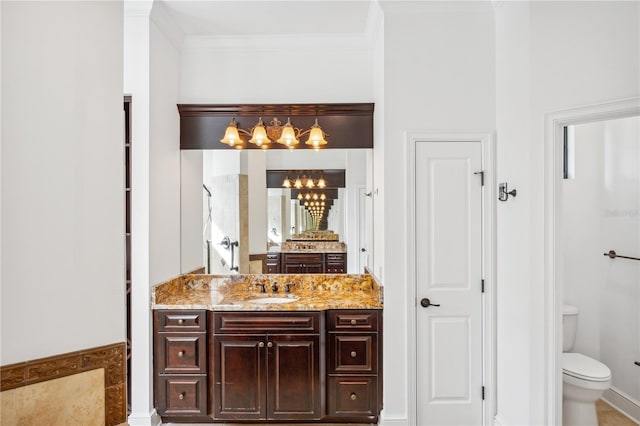 bathroom with a chandelier, toilet, ornamental molding, tiled shower, and vanity