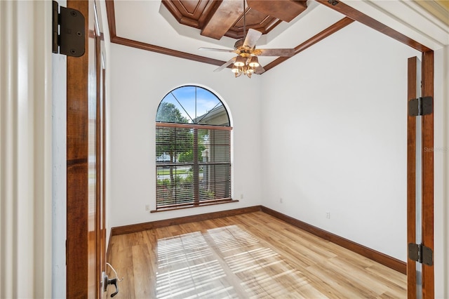 empty room featuring crown molding, a ceiling fan, baseboards, and light wood finished floors